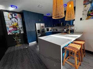 uma cozinha com armários azuis e um balcão com bancos em Luxury Condo at Los Sueños Resort & Marina em La Mona
