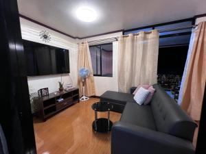 sala de estar con sofá y mesa en Joymendz en San Jose de Buenavista