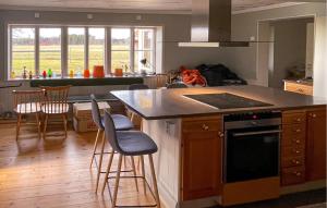 a kitchen with a island with bar stools in it at 4 Bedroom Cozy Home In Jnkping in Jönköping