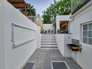 a stairway leading to a white house with a gate at Braai, Outdoor dining area, workstation, Fast Wi-Fi in Cape Town