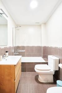 a bathroom with a toilet and a tub and a sink at El retiro de nirvana in Castellanos de Moriscos