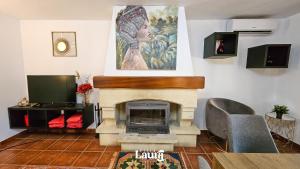 una sala de estar con chimenea y una pintura en la pared en Villa Laura, en Alhaurín el Grande