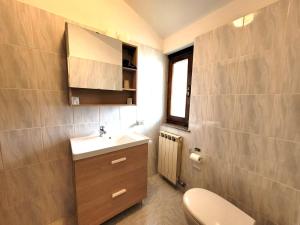 a small bathroom with a toilet and a sink at Panorama Verde Lago - Mountain Lake Iseo Hospitality in Bossico