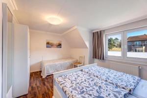 ein kleines Schlafzimmer mit einem Bett und einem Fenster in der Unterkunft Haus Richard in Ahlbeck