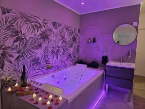 d'une salle de bains pourpre avec baignoire et lavabo. dans l'établissement Suite romantique tropicale, à Vienne