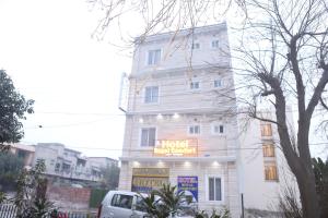 Un bâtiment blanc avec un panneau en haut dans l'établissement Hotel Royal Comfort, à Lahore