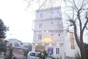 un edificio bianco con un cartello sopra di Hotel Royal Comfort a Lahore