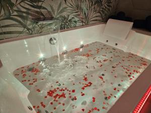 une baignoire pleine de fleurs rouges dans l'établissement Suite romantique tropicale, à Vienne