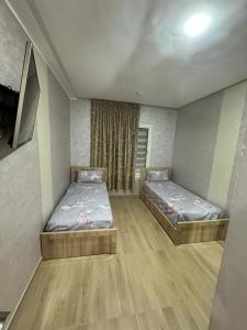 2 camas en una habitación con suelo de madera en appart luxe CORALIA 34 IL 7 en Oujda