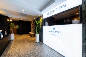 a lobby of a hotel with a make stay sign at Jamsil Noblestay Hotel in Seoul