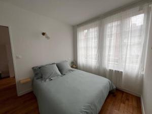 una camera bianca con un letto e una finestra di Appartement centre - Avranches ad Avranches