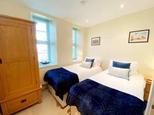 a bedroom with two beds and a window at Sea View Apartment, 7 Ellington Court in Torquay