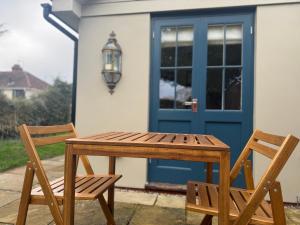 una mesa de madera y 2 sillas frente a una puerta en Enchanting 1 Bedroom Home with Kitchen en Saffron Walden