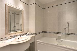 a white bathroom with a sink and a bath tub at Macdonald Leeming House in Watermillock +38 photos