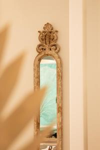 een oude spiegel aan een muur in een kamer bij Front Sea Apartment in Quarteira