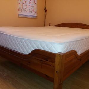 a wooden bed with a white mattress on it at Romantic Spirit in Riga in Rīga