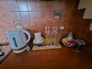 a kitchen counter with two glasses and a coffee maker at Apartament Ogrody RELAX TIME in Poznań