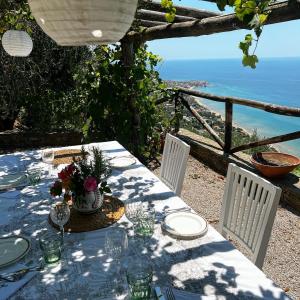 una mesa con platos blancos y vistas al océano en Casale Santa Rosalia, en San Mauro Cilento
