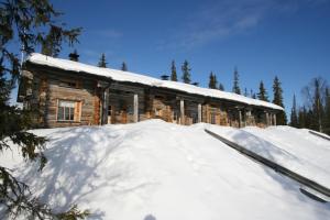 a log cabin in the snow with a pile of snow at Holidayhome Hoviranta in Luosto +9 photos