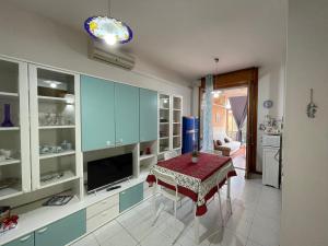 una cocina con armarios azules y una mesa. en Domus Sarda, en Capitana