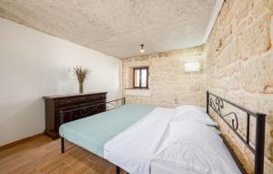 een slaapkamer met een bed en een stenen muur bij 2 Bedroom Amazing Home In Obrovac Sinjski in Obrovac Sinjski