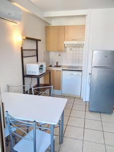 eine Küche mit einem weißen Tisch und einem Kühlschrank in der Unterkunft Résidence Graziella Studio 624 in Juan-les-Pins