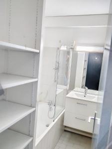 ein weißes Badezimmer mit einem Waschbecken und einem Spiegel in der Unterkunft Résidence Graziella Studio 624 in Juan-les-Pins