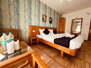 a bedroom with a bed with a mirror and a table at Mountain View Resort - A Hidden Resort Manali in Manāli