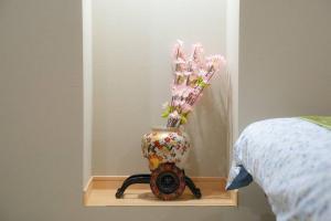 un jarrón con flores en él sentado en una mesa en Guest House HARU DREAM ABENO HOUSE, en Osaka