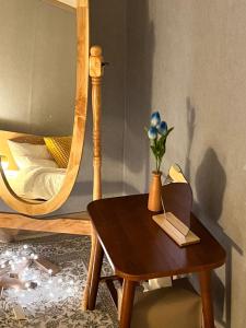 a wooden table with a vase of flowers on it next to a bed at Masil in Seoul