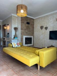 Cama amarilla grande en habitación con chimenea en Refugio da Longueira, en Longueira