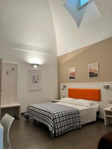 Schlafzimmer mit einem Bett mit orangefarbenem Kopfteil in der Unterkunft Nova Domus in Castellaneta