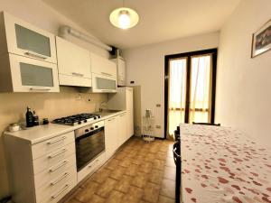 a kitchen with white cabinets and a stove top oven at Panorama Verde Lago - Mountain Lake Iseo Hospitality in Bossico