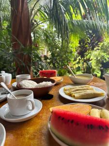 a table with plates of food and cups of coffee at Ama Eco Lodge in Sigiriya