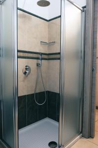 La salle de bains est pourvue d'une douche avec une porte en verre. dans l'établissement Bella Napoli albergo Chiari, à Chiari