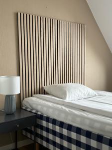 a bed with a wooden headboard next to a table at Hotell Gillet i Köping in Köping