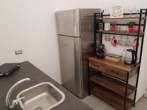 een keuken met een roestvrijstalen koelkast en een wastafel bij Momenti e wellness in Siracusa