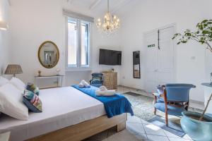 1 dormitorio con 1 cama y 2 sillas azules en Cozy Carisma Lodging - Central, New and Independent Studio Apartment, en Sliema