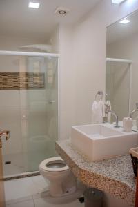 uma casa de banho com um lavatório, um WC e um chuveiro em Imbassaí Apartments em Imbassaí