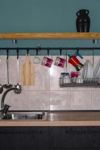 un lavello con utensili da cucina su uno scaffale sopra di esso di La casetta a San Marco Evangelista