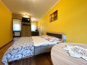 two beds in a room with yellow walls at Apartamenty i pokoje w Zawoi Dorota Miśkowiec in Zawoja