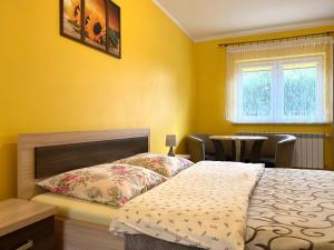 a bedroom with yellow walls and a bed and a table at Apartamenty i pokoje w Zawoi Dorota Miśkowiec in Zawoja