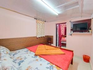 a bedroom with a bed with a red blanket at AKS Home Stay in Munnar