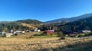 a small village in a field with mountains in the background at Apartamenty i pokoje w Zawoi Dorota Miśkowiec in Zawoja