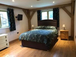 a bedroom with a king sized bed and windows at Oak Lodge in Tavistock