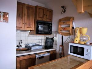 kuchnia ze zlewem i mikrofalówką w obiekcie Studio cosy avec mezzanine et balcon au pied des pistes - FR-1-297-158 w mieście Auris