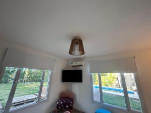 ein Wohnzimmer mit zwei Fenstern und einem hängenden Licht in der Unterkunft General Roca hermosa habitacion con baño privado in General Roca