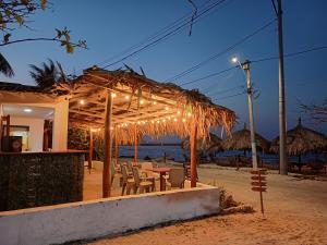 a restaurant with a table and chairs on the beach at Punta Arena Beach Hostel in Playa Punta Arena