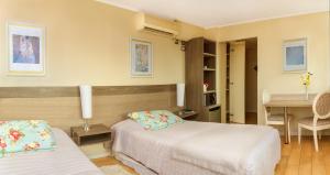 Habitación de hotel con 2 camas y mesa en Hotel Aranjuez, en Chillán