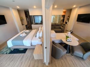 a bedroom with a large bed and a living room at Chinatown Living Hatyai in Hat Yai